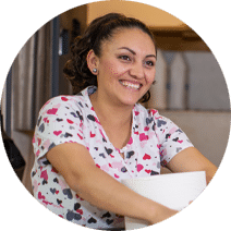 Woman in scrubs with hearts smiling